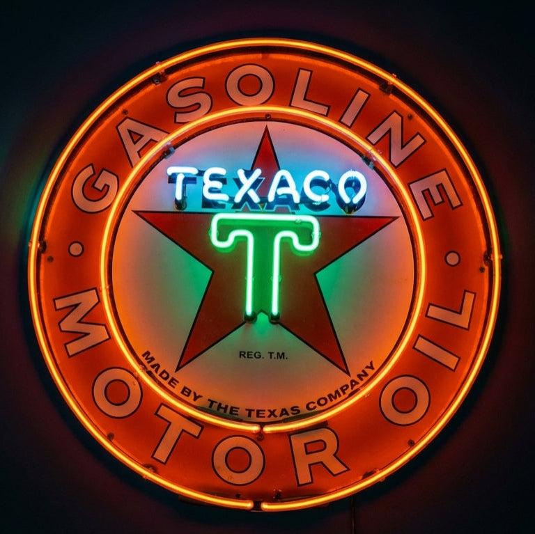 Neon sign of Texaco logo on a dark background