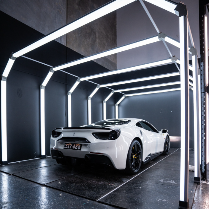 White sports car in a futuristic garage with neon lights