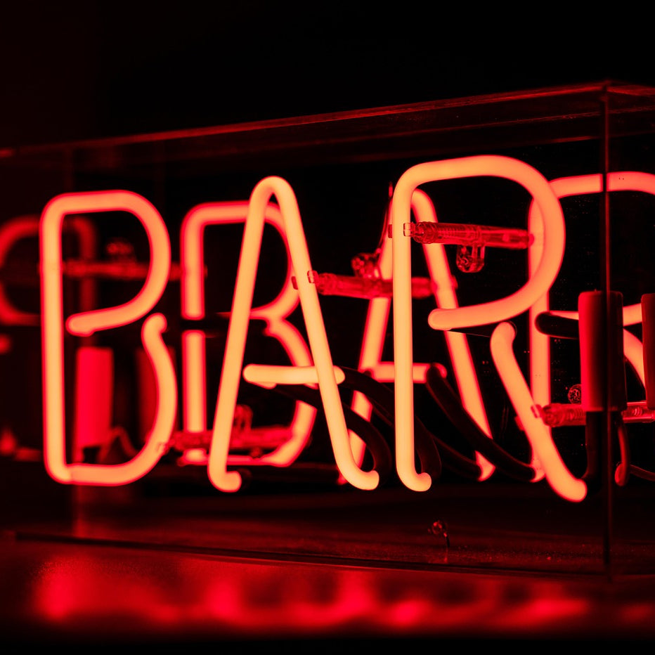 Neon sign with the word 'BAR' inside a clear acrylic box on a black background